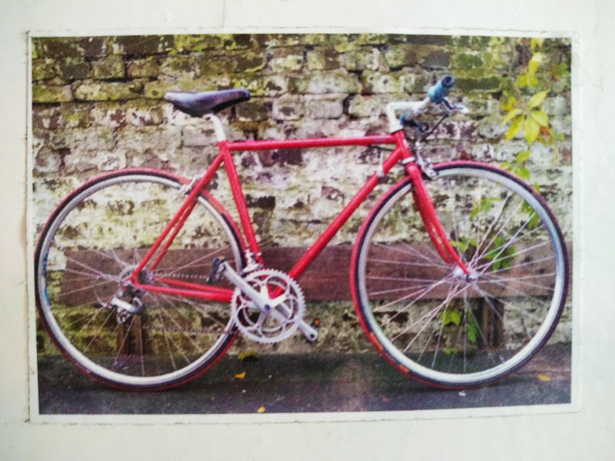 Rotes Rennrad an einer alten Backsteinmauer
